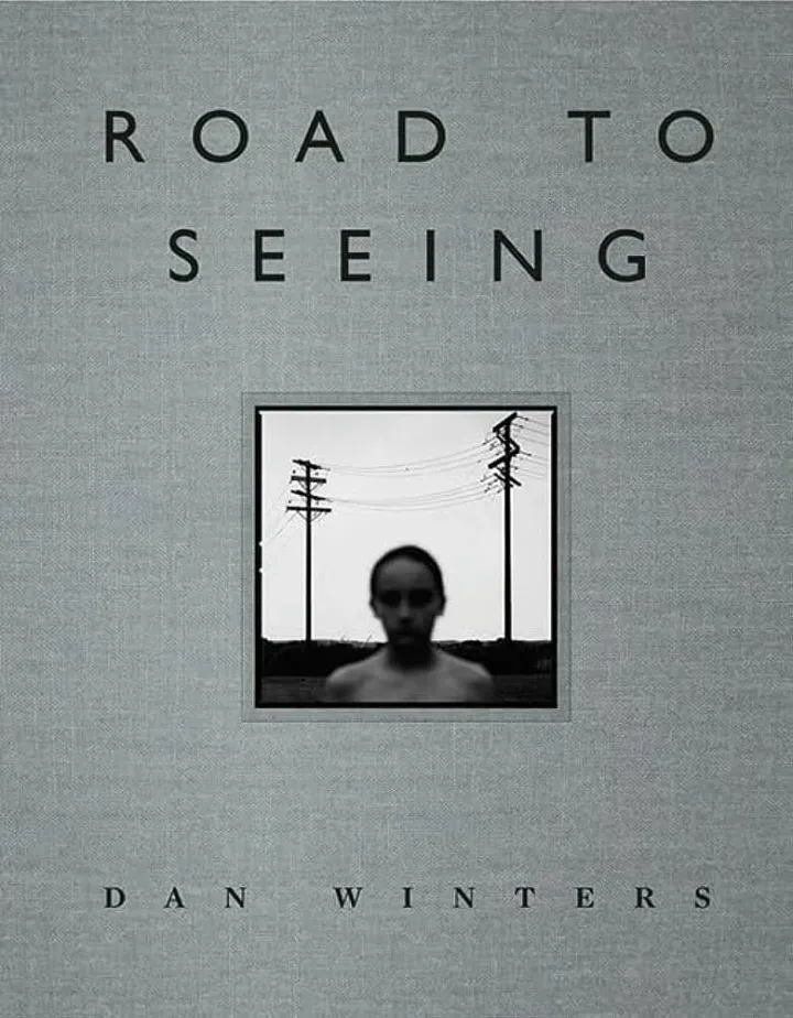 Book cover titled "Road to Seeing" by Dan Winters, featuring a blurred black and white photograph of a person with power lines in the background.
